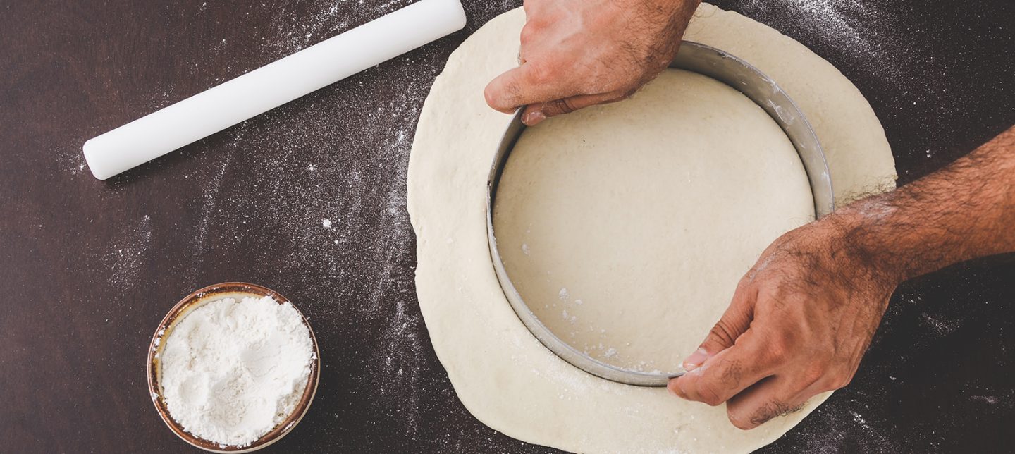 person cutting out dough